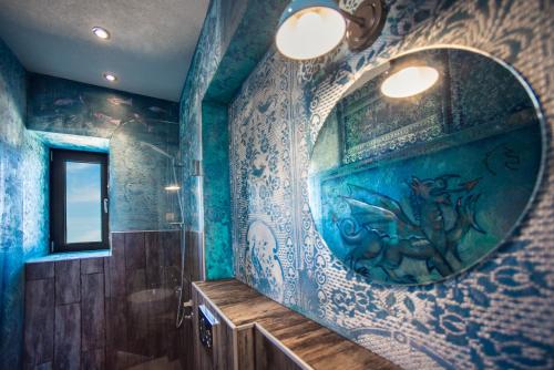 baño con paredes azules y espejo grande en Keros Blue - Luxury in Wilderness, en Kalliópi