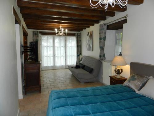 um quarto com uma cama azul e um sofá em Gite de Cray em Lussault-sur-Loire