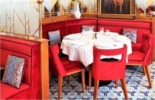 a dining room with a table and red chairs at Hotel Restaurant Au Boeuf Couronné in Paris