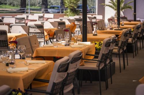 a row of tables with yellow table cloths and chairs at Guest House Navetta 2 in Fažana