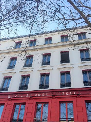 a large white building with a red facade at Hotel Restaurant Au Boeuf Couronné in Paris
