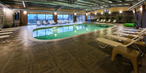 a large pool in a building with chairs and tables at Royal Valentina Castle in Ognyanovo