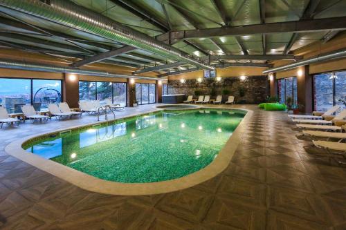 a large pool in a hotel with chairs and tables at Royal Valentina Castle in Ognyanovo