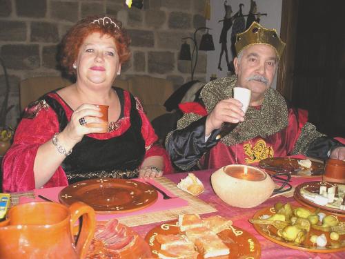 a man and a woman sitting at a table with food at TORRE FUERTE Siglo XIII in Baños de Rioja