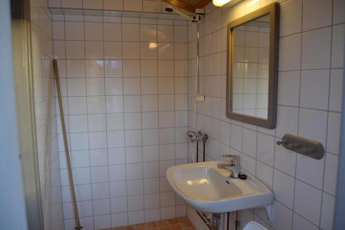 een witte badkamer met een wastafel en een spiegel bij Vekve Hyttetun in Oppdal