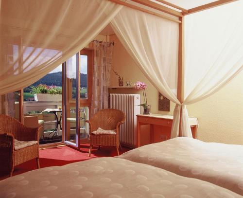Schlafzimmer mit einem Bett und Blick auf einen Balkon in der Unterkunft Haus Farbenklang in Zwiesel