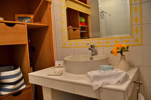 a bathroom with a sink and a vase of flowers at Apartamento Silveira in Furnas