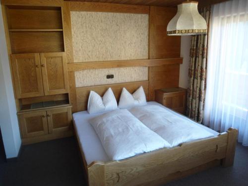 トゥクスにあるHaus Marionのベッドルーム1室(木製ヘッドボード付きのベッド1台付)