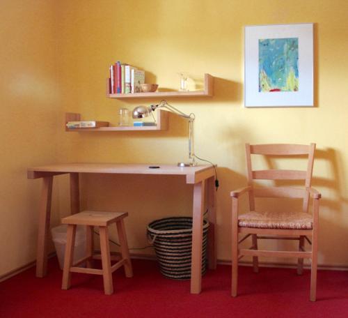 a desk with a lamp and a chair in a room at Haus Farbenklang in Zwiesel