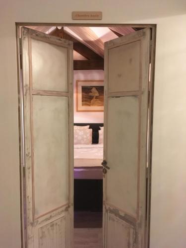 an open door in a room with a bed at Moulin de la Fayolle in Blot-lʼÉglise