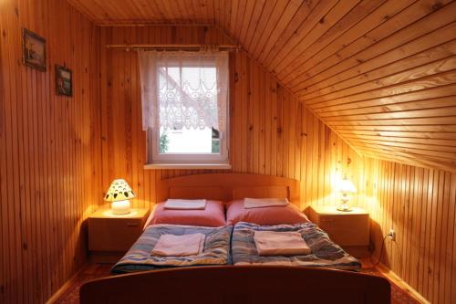 LipnicaにあるAgroturystyka Pod Pstrągiemの窓付きの木造の部屋のベッド1台