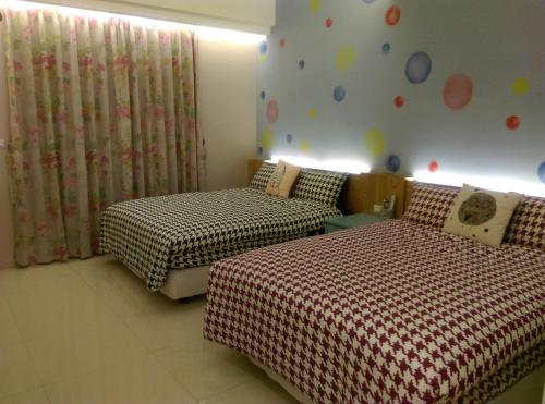 a bedroom with two beds and a wall with polka dots at Shuiquan 19N in Hengchun South Gate