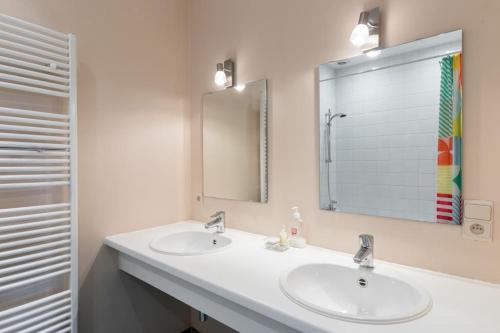 La salle de bains est pourvue de 2 lavabos et d'un grand miroir. dans l'établissement Fantastic Large House, à Bruxelles