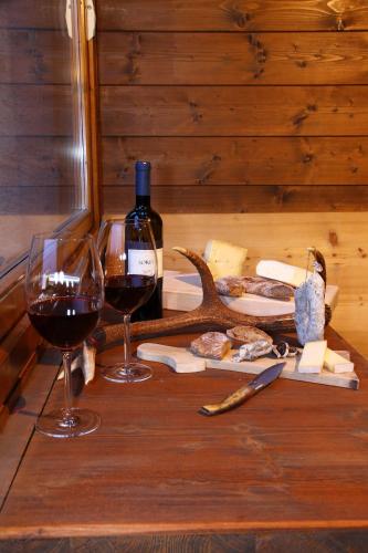 a table with two glasses of wine and cheese at Chalet dell'Ermellino in Bormio
