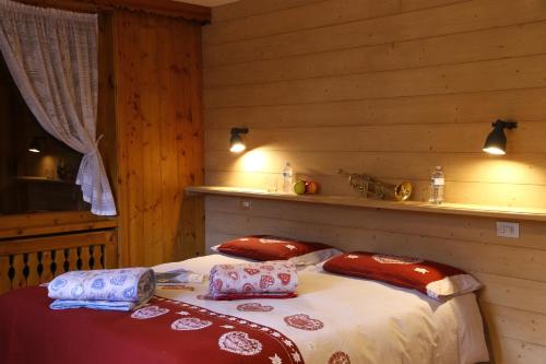 um quarto com uma cama com almofadas em Chalet dell'Ermellino em Bormio