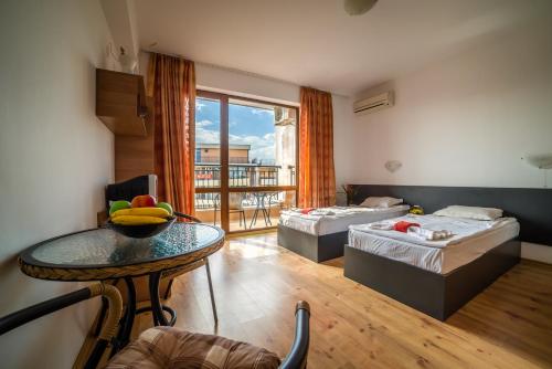 a room with two beds and a table with fruit on it at Step Hotel in Sunny Beach
