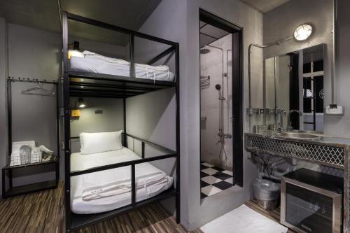 een kamer met 2 stapelbedden en een badkamer bij 和平公獄監獄文旅 近東大門夜市 Peace Prison Cafe Inn in Hualien