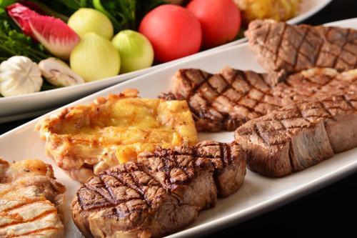 a plate of food with meat and apples on a table at Ise City Hotel in Ise