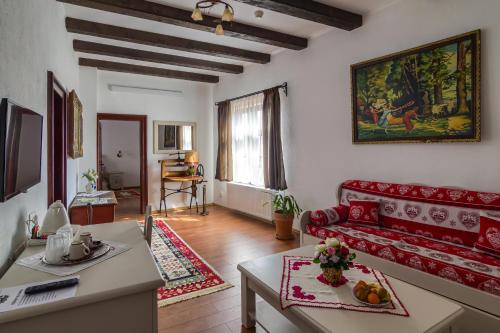 a living room with a red couch and a table at Taschler Haus in Sighişoara