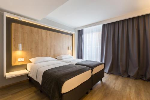 a bedroom with a large bed and a large window at M Hotel in Ljubljana