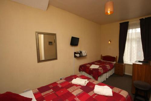 Habitación de hotel con 2 camas y espejo en Boltonia, en Blackpool