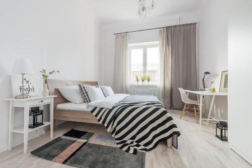 ワルシャワにあるP&O Apartments Andersa INTRACOの白いベッドルーム(ベッド1台、テーブル付)