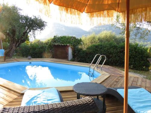 a swimming pool with two chairs and an umbrella at Hotel mon Soleil in La Gaude