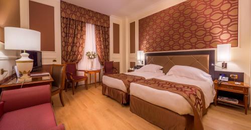 a hotel room with a large bed and a desk at Grand Visconti Palace in Milan