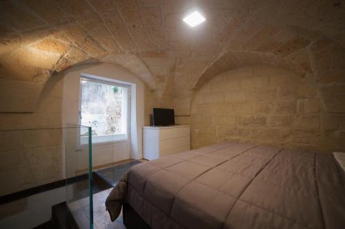 a bedroom with a bed in a stone wall at Suite del Teatro Romano in Lecce
