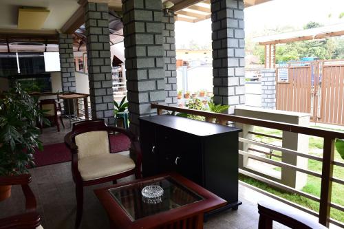 a balcony with a table and chairs on a porch at Srinikethana Home Stay with Swimming Pool in Madikeri