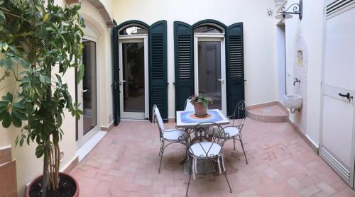 a patio with a table and chairs and a potted plant at B&B San Potito in Matera