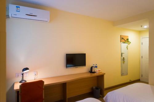 a room with a desk with a television on a wall at Home Inn Cahngzhi East Taihang Street in Changzhi