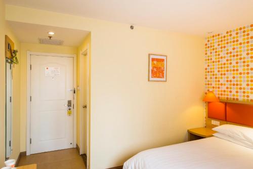 a hotel room with a bed and a door at Home Inn Cahngzhi East Taihang Street in Changzhi