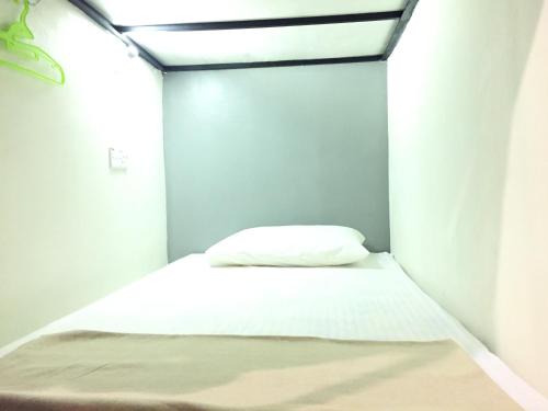 a small bedroom with a white bed in it at Sunset Homestay - Backpacker Hostel Self Checkin in Kuching
