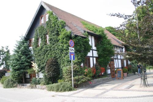 a building covered in ivy with a sign in front of it at Fisherman's House in Ustka