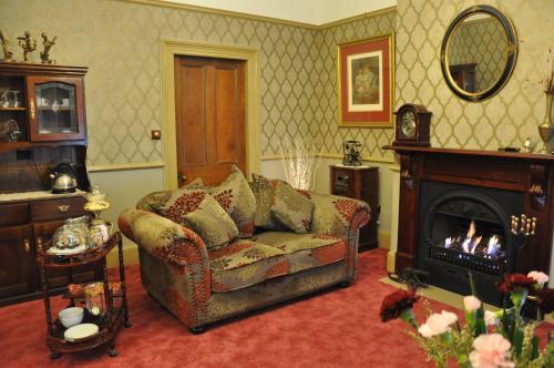 a living room with a couch and a fireplace at Bli Bli House Riverside Retreat in Twin Waters