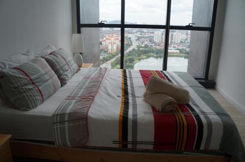 een groot bed in een kamer met een groot raam bij M City @ Jalan Ampang KLCC in Kuala Lumpur