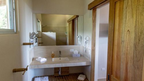 a bathroom with a sink and a large mirror at Vista Villas in Ojochal