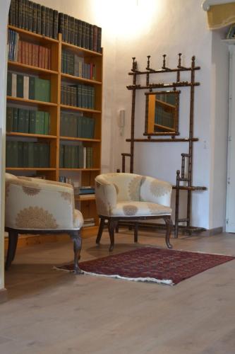 two chairs and a mirror in a room with books at Risveglio Ibleo in Ragusa