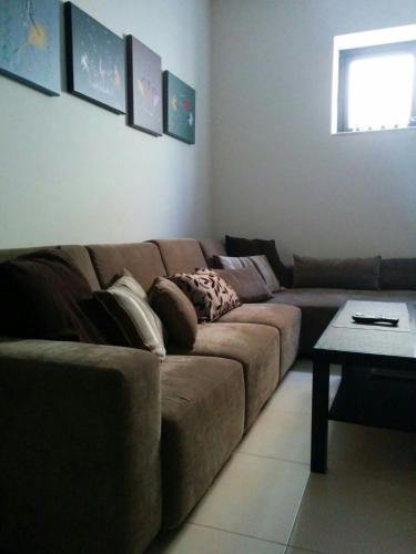 a living room with a brown couch and a table at Mandalay in Mellieħa