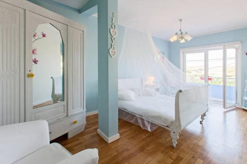 Un dormitorio con una cama blanca y un espejo. en CAMINHOS DE SANTIAGO - VillaMaria BEACH HOUSE, en Leça da Palmeira