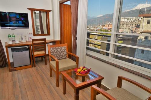 a living room with a table and a view of a city at Mount View Pokhara in Pokhara