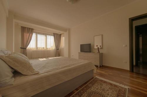 a bedroom with a large bed and a television at Samali Residence in Eforie Nord