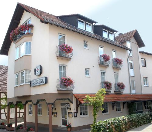 een groot wit gebouw met bloembakken erop bij Hotel Stadtschänke in Bad König