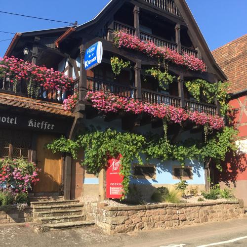 a building with flowers on the side of it at Hotel Kieffer in Itterswiller