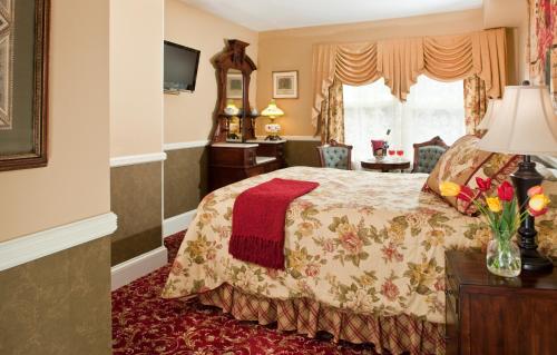 a hotel room with a bed and a window at The Queen Victoria in Cape May