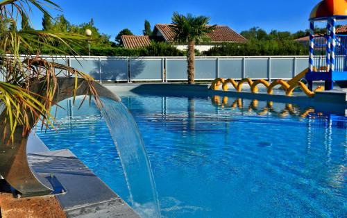 a swimming pool with a water slide in a resort at Domaine Les Abberts in Arès