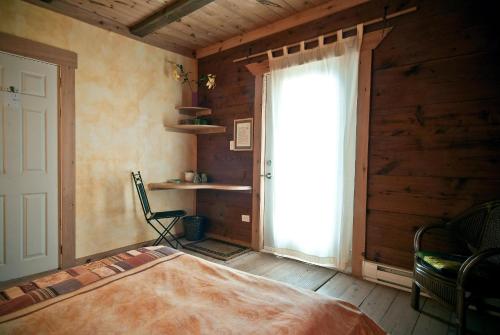 a bedroom with a bed and a large window at Green Dragon Organic Farm and B&B in Tatamagouche