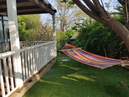 a hammock on a porch of a house at Betzel Ha'Ella in Kahal