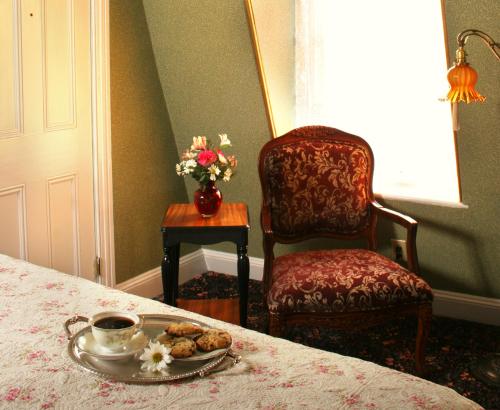a table with a plate of food and a chair at The Queen Victoria in Cape May